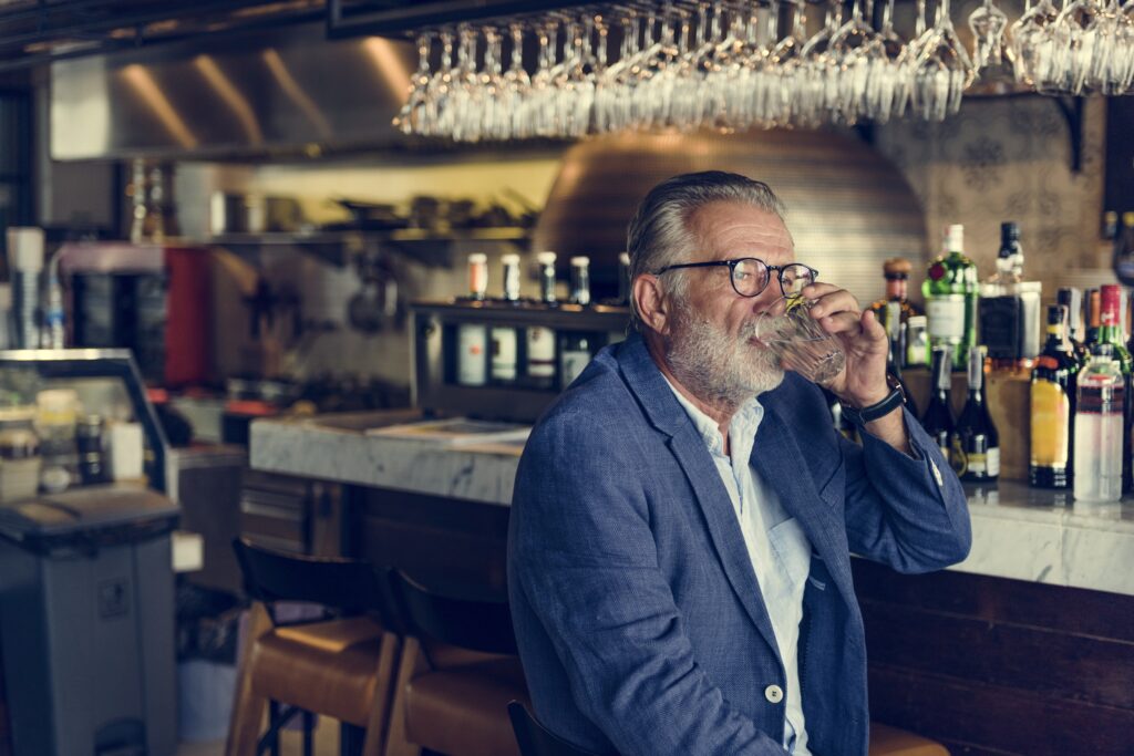 Older gentleman at a bar drinking in a pattern consistent with gray area drinking.