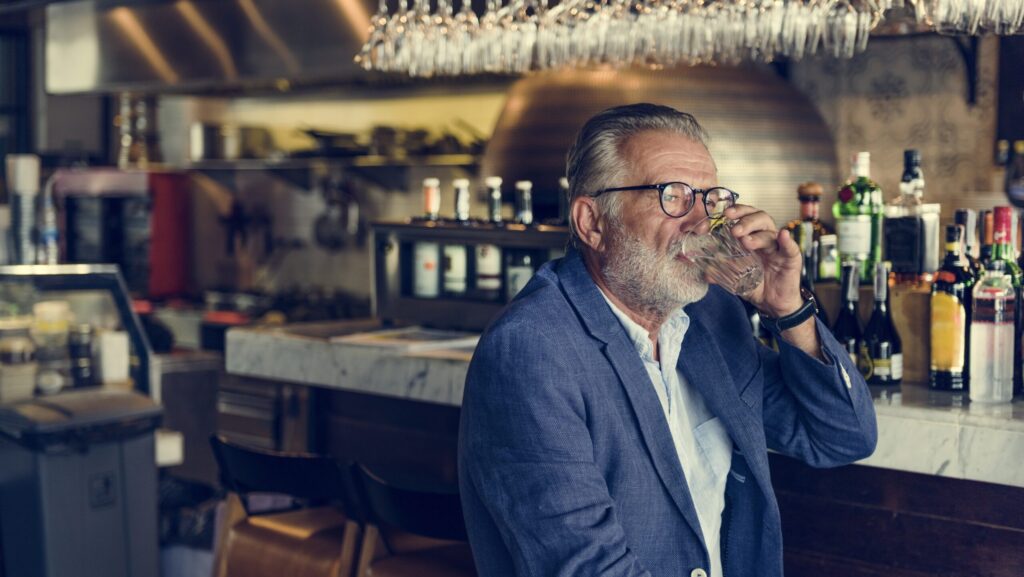 Older gentleman at a bar drinking in a pattern consistent with gray area drinking.