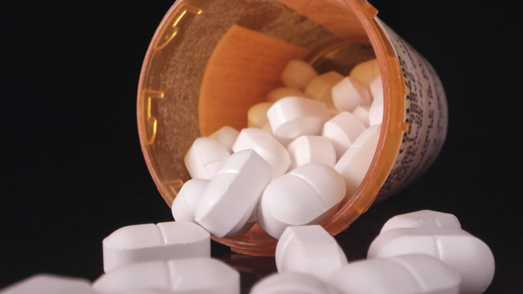A pharmaceutical bottle of pills represents medications that can be used during rapid medical detox.