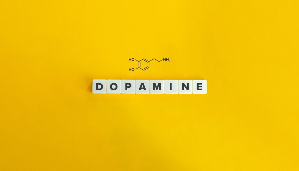 The words dopamine spelled out on a yellow background represents the potential to experience dopamine withdrawal with certain substances.