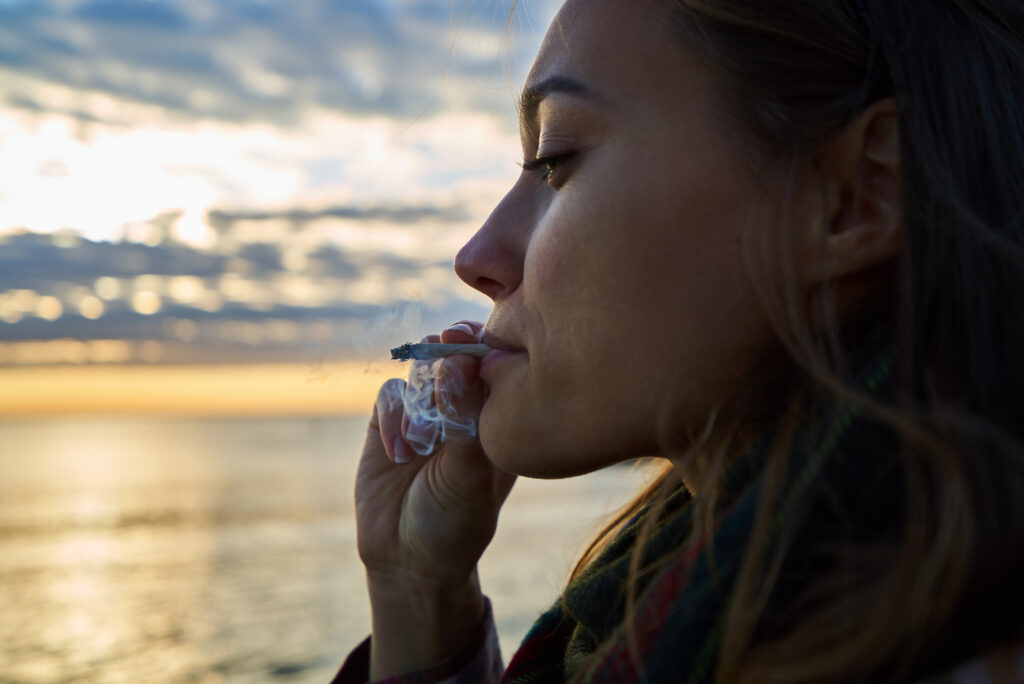 A young woman smoking a blunt goes through the different stages of being high on cannabis.