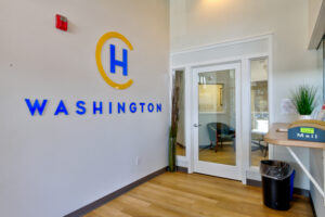 Hotel California by the Sea Washington logo on grey wall, light wooden floor and receptionist desk