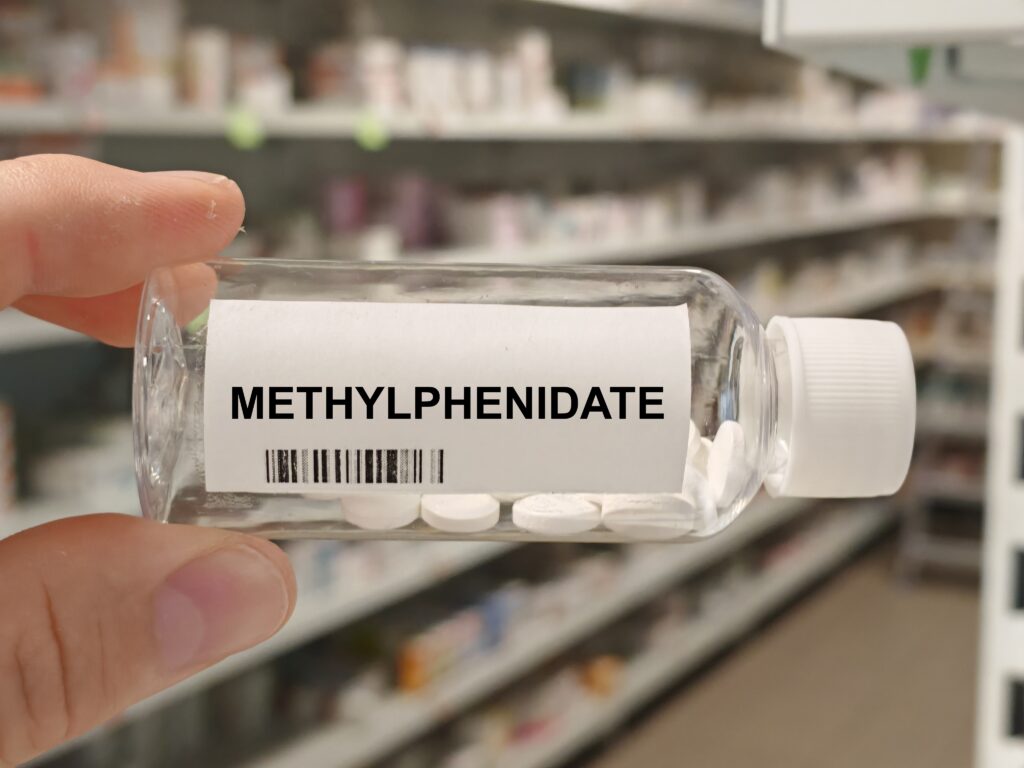 A clear bottle with pills of methylphenidate represent the differences of Adderall vs Ritalin.