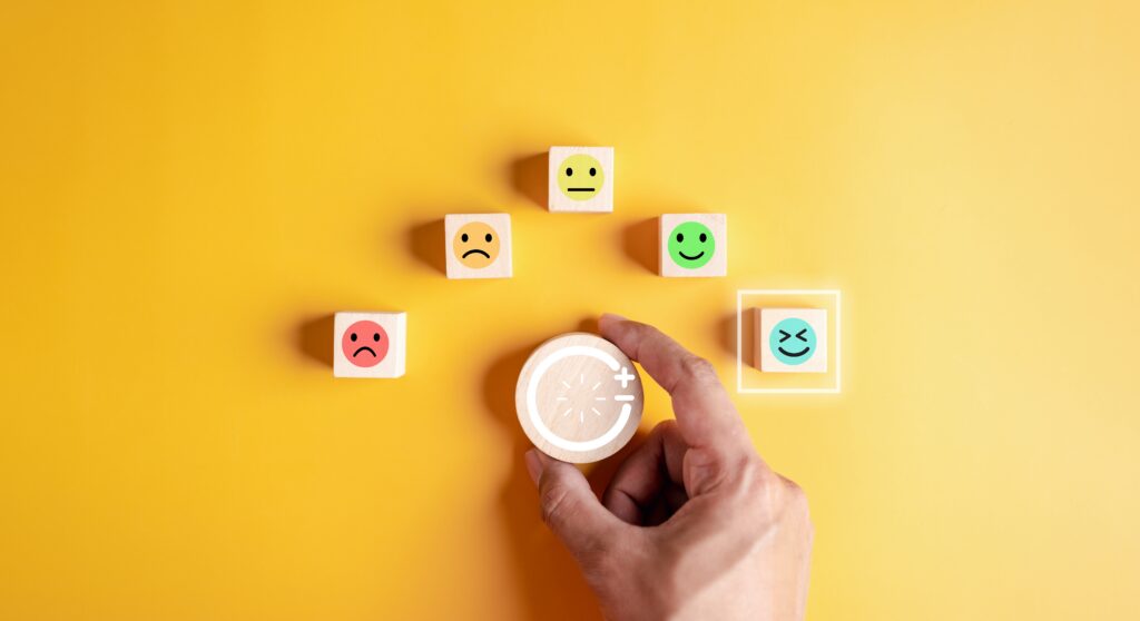 Wooden blocks with various faces ranging from sad to happy represent how people can incorporate natural ways to produce dopamine.