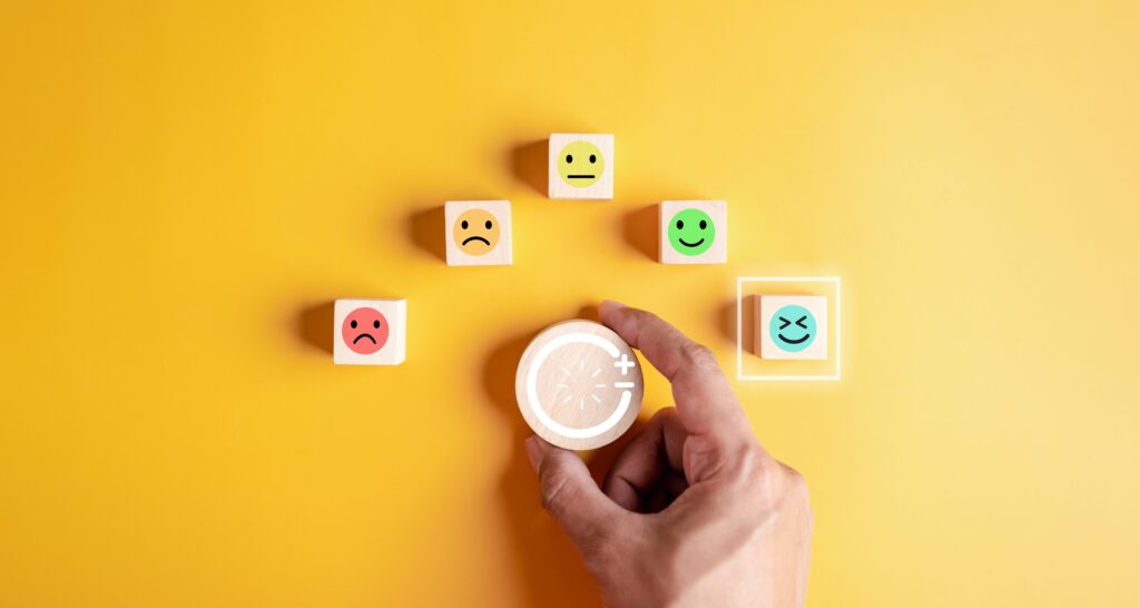 Wooden blocks with various faces ranging from sad to happy represent how people can incorporate natural ways to produce dopamine.