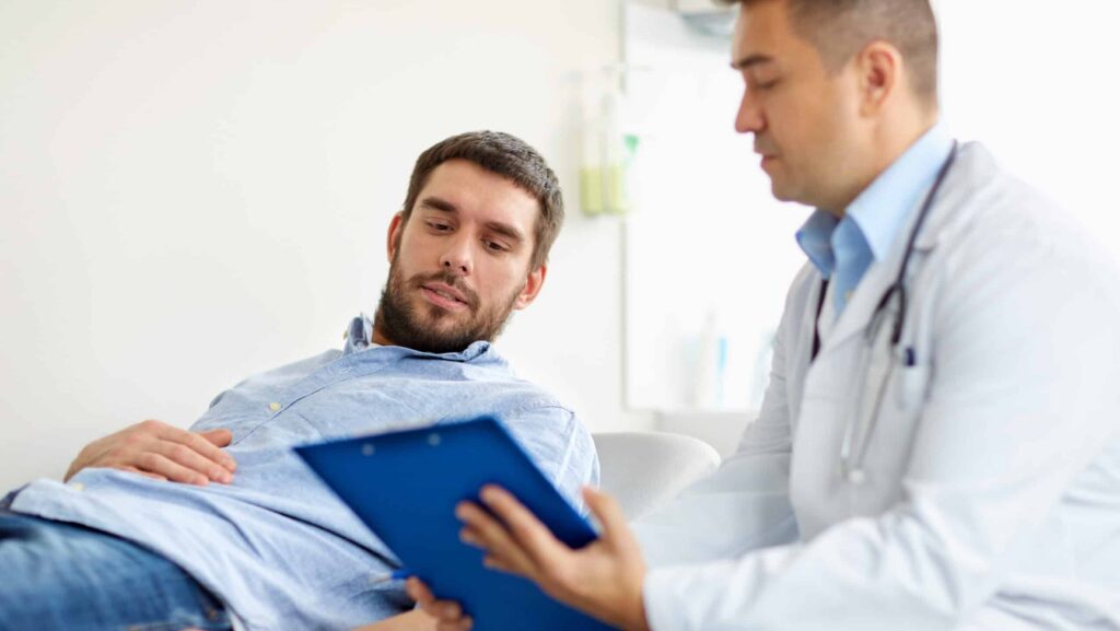 In a clinic setting, a man is speaking with his healthcare provider in an attempt at doctor shopping to receive more prescriptions and refills on his medication.